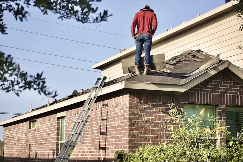 Professional roofer working on a residential roof in Masonville